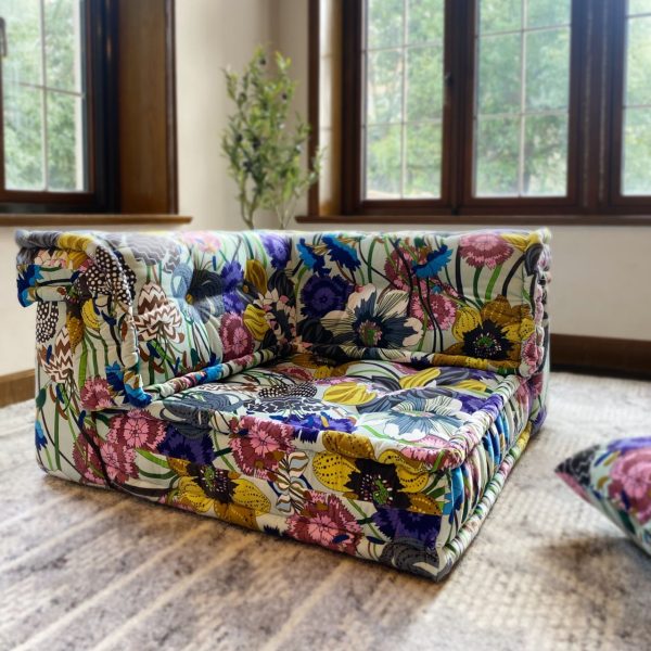 French Daybed Mah Jong Sofa, Corner Seater in floral fabric with colorful flower patterns, placed near a window with a leafy view