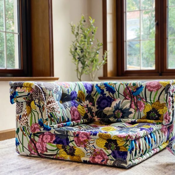 French Daybed Mah Jong Sofa Corner Seater in floral upholstery with colorful patterns, positioned in a bright room with large windows.