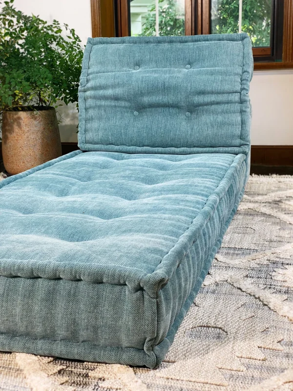 French Mah Jong Daybed Sofa arranged in a cozy, light-filled room with large windows and greenery.