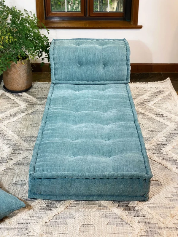 Plush Mah Jong Daybed Sofa in teal fabric set against a bright and modern living room with greenery accents.