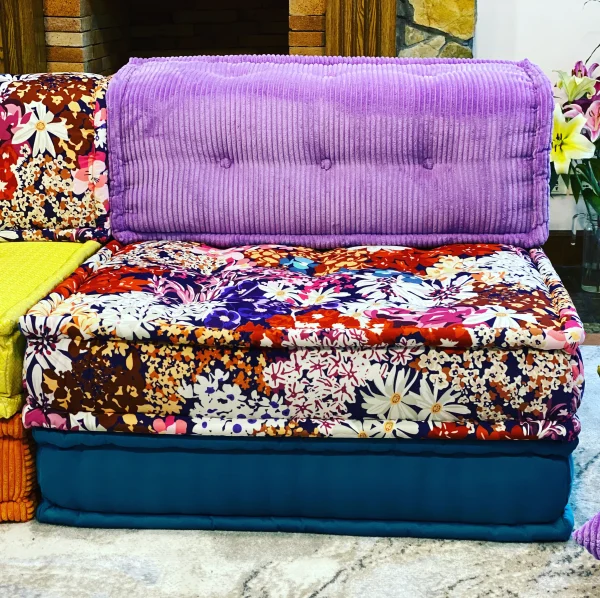 Eclectic Mah Jong sofa with vibrant purple cushions and a colorful floral base, styled in a boho-inspired living room.