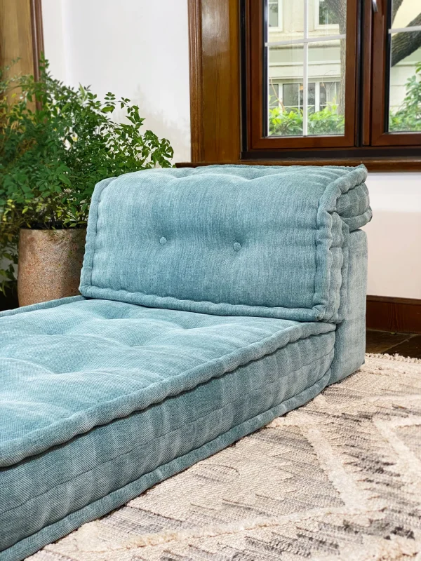 French Mah Jong Daybed Sofa arranged in a minimalist room with wooden accents and indoor greenery.