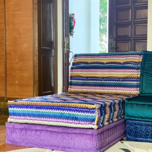 Colorful striped Mah Jong sofa with purple base and zigzag pattern in a sunlit living space.