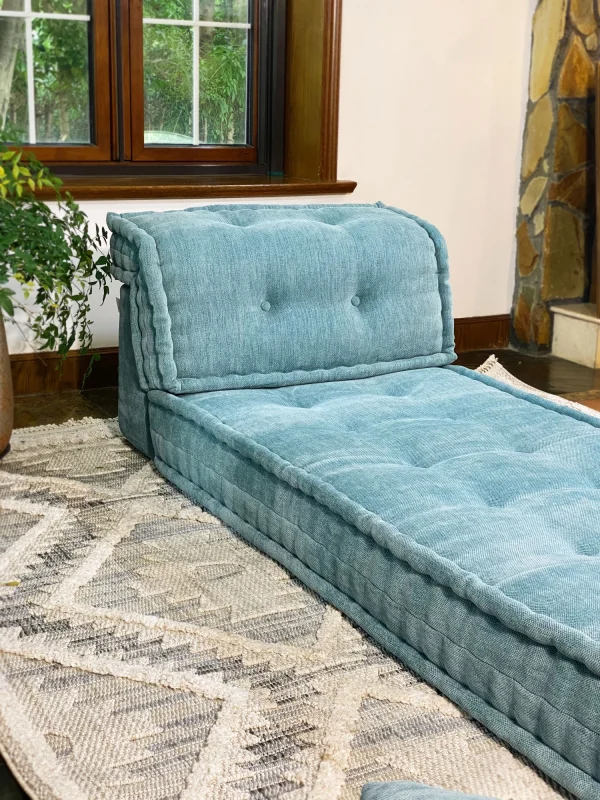 Side angle of a French Mah Jong Daybed Sofa in teal fabric, showcasing its tufted backrest and soft edges.