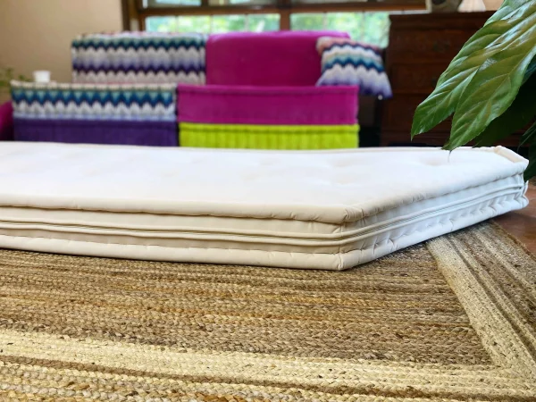 Close-up of a white cushion pad on a jute rug, part of a Mah Jong modular sofa set.