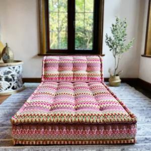 French Daybed Mah Jong sofa featuring vibrant pink and green patterned upholstery in a cozy living room setting.