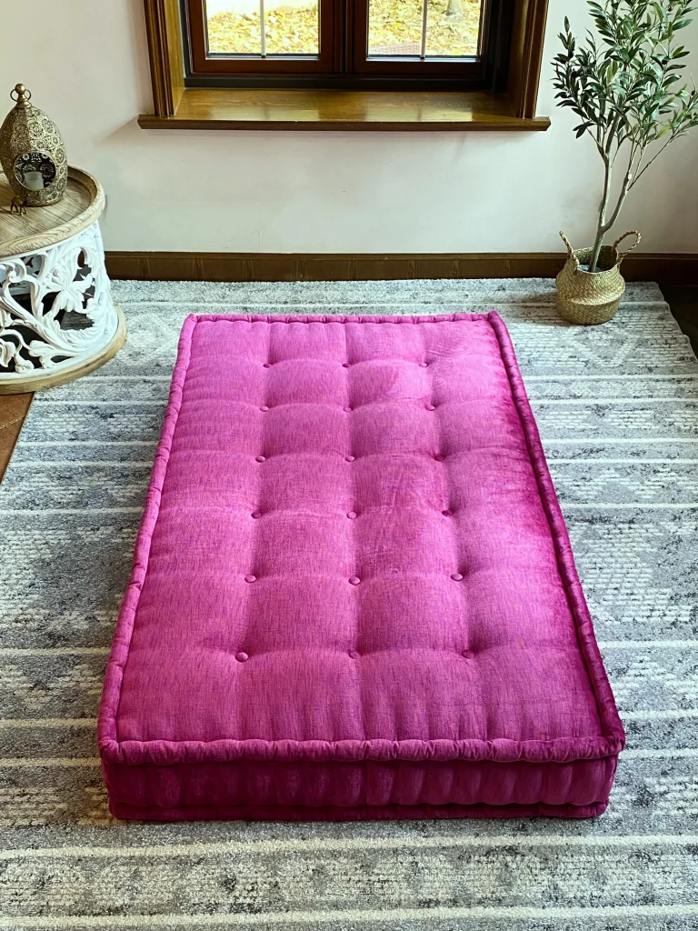 French Mah Jong daybed sofa featuring a bold pink tufted cushion, styled in a cozy interior with natural lighting.
