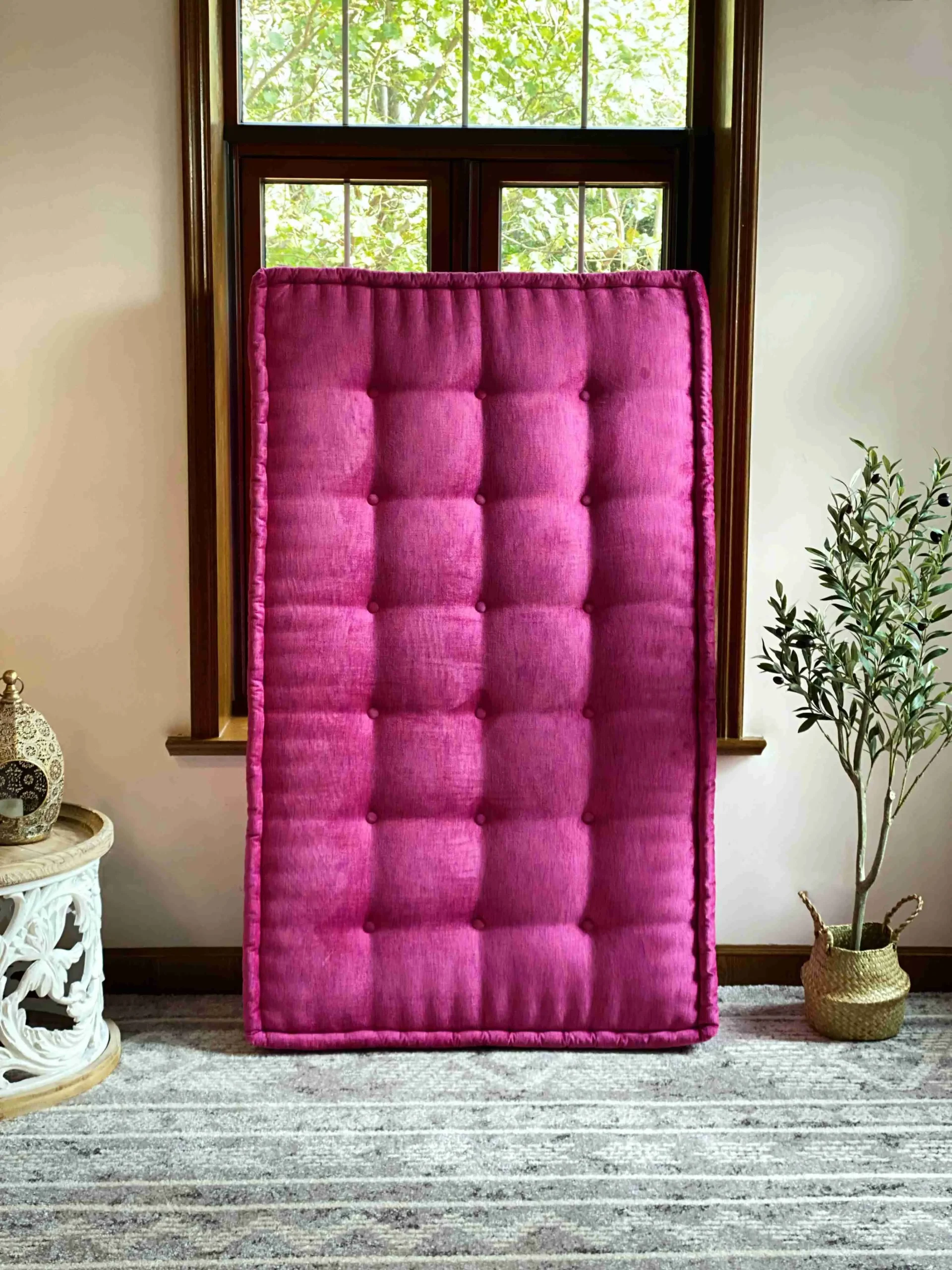 Pink Mah Jong daybed cushion positioned vertically, emphasizing its bold color and elegant tufted details.