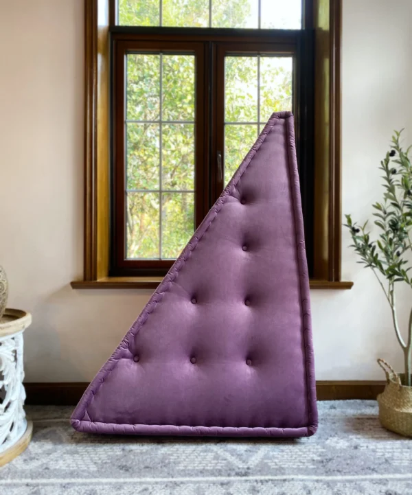 Purple triangular cushion from the French Daybed Mah Jong Sofa, showcased vertically in a sunlit room with natural elements.