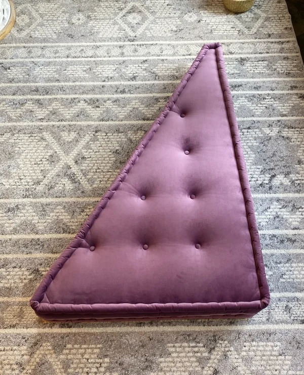 French Daybed Mah Jong Sofa with a purple triangular cushion styled on a textured rug for a minimalist look.