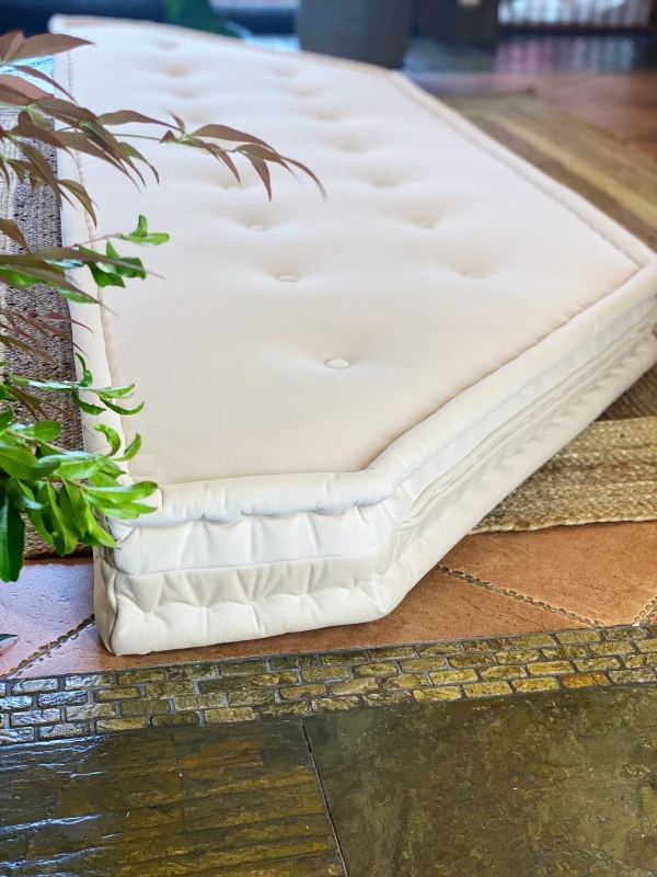 White French daybed Mah Jong sofa with tufted details surrounded by natural indoor plants.