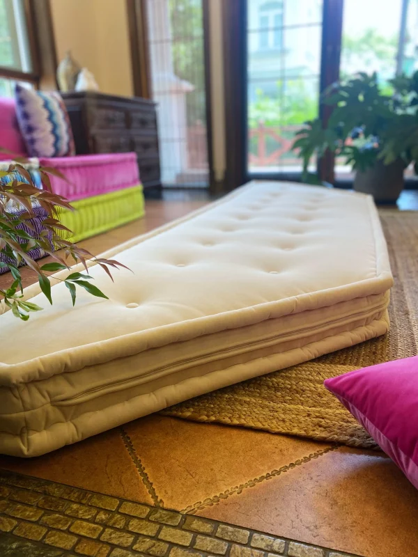 Stylish French daybed Mah Jong sofa with a white cushion, set in a colorful modern living room.