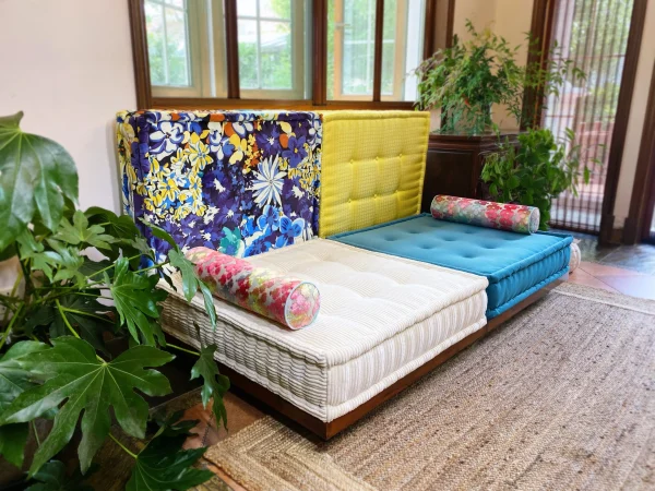 Full view of Mah Jong Sofa with blue and white cushions, vibrant backrests, and colorful bolsters styled in a modern living space.