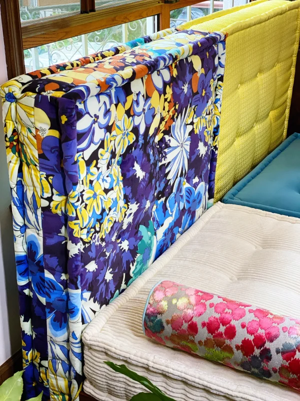 Close-up of the French Daybed Mah Jong Sofa showing vibrant floral backrest and textured cushions.