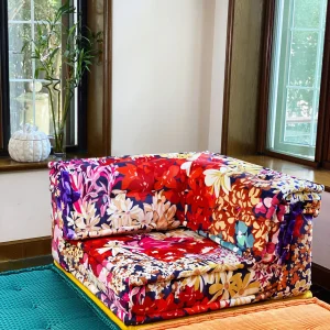 Floral-patterned Mah Jong sofa with multicolored cushions in a bright, cozy living room.