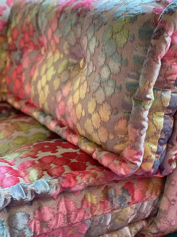 Close-up of a colorful Mah Jong sofa with shimmering floral upholstery and button detailing for a luxurious look.