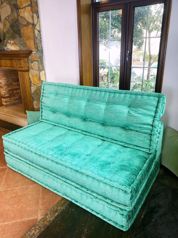 Side view of a turquoise Mah Jong daybed with stacked cushions and soft upholstery, ideal for luxurious interiors.