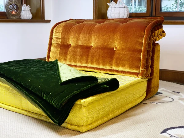 Green quilted velvet Mah Jong sofa styled in a room with natural lighting and minimalist decor.