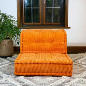 Vibrant orange French Mah Jong Daybed Sofa in a cozy living room with natural light and a textured rug.