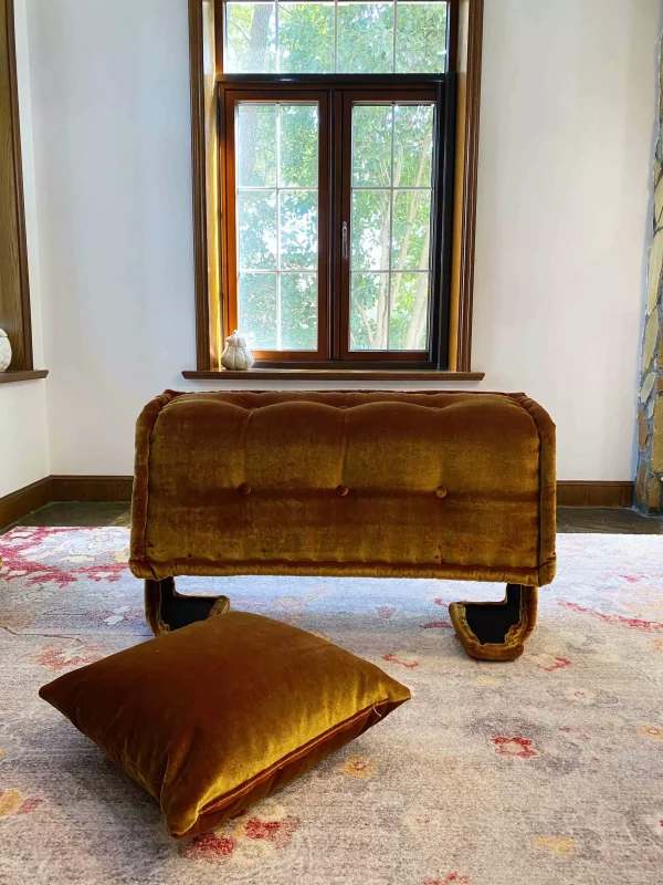 French daybed Mah Jong sofa positioned by a window, folded upright with soft light filtering in.