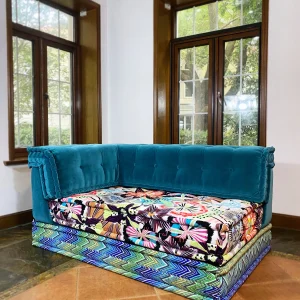 Close-up of Mah Jong daybed featuring teal velvet and detailed chevron and floral cushion designs.