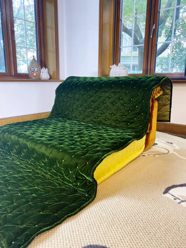 Green quilted velvet Mah Jong sofa styled in a room with natural lighting and minimalist decor.