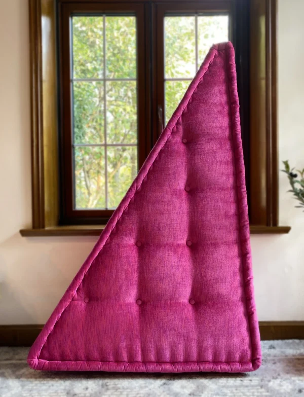 Vertically stacked magenta cushion from the Mah Jong sofa, showcasing tufted details against a sunlit window.