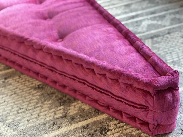 Side view of the lavender and magenta cushion layers on the Mah Jong sofa, styled on a patterned rug.