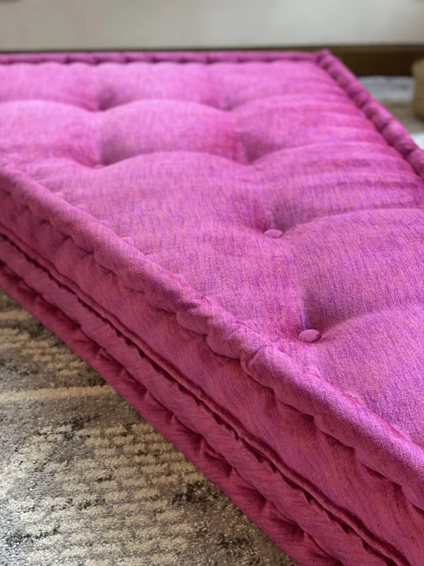 Close-up of the magenta cushion on a Mah Jong daybed sofa, highlighting tufted details and soft fabric texture.