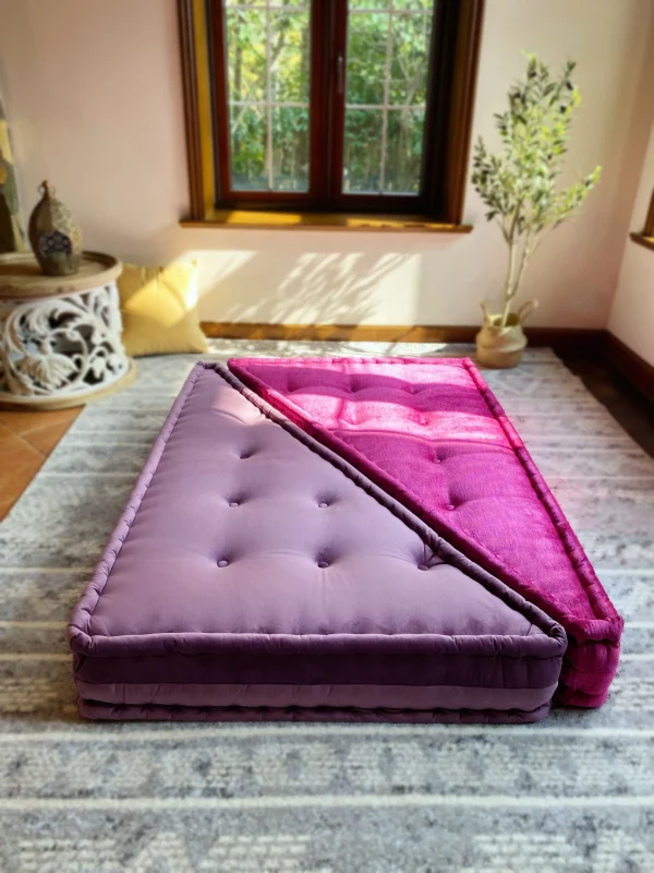 French daybed Mah Jong sofa with a soft lavender and magenta cushion arrangement, styled in a sunlit living room.