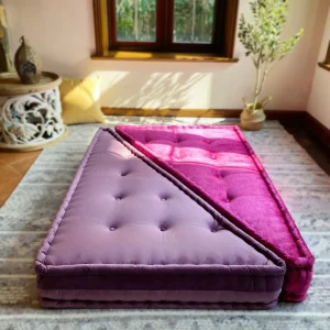 French daybed Mah Jong sofa with a soft lavender and magenta cushion arrangement, styled in a sunlit living room.