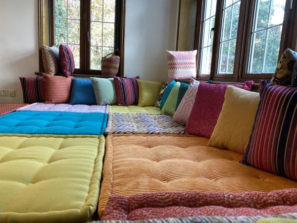 A Mah Jong daybed with eye-catching zigzag and floral patterns, paired with solid and striped cushions for a striking design.