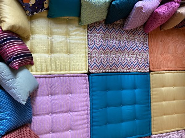 Overhead view of a Mah Jong daybed’s cushion arrangement, emphasizing a mix of bold colors and detailed patterns.