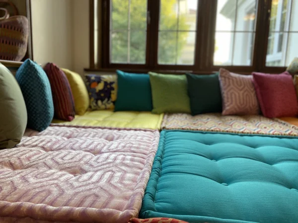 Geometric-patterned Mah Jong daybed with tufted cushions in yellow, purple, and multicolor, perfect for a modern interior design.