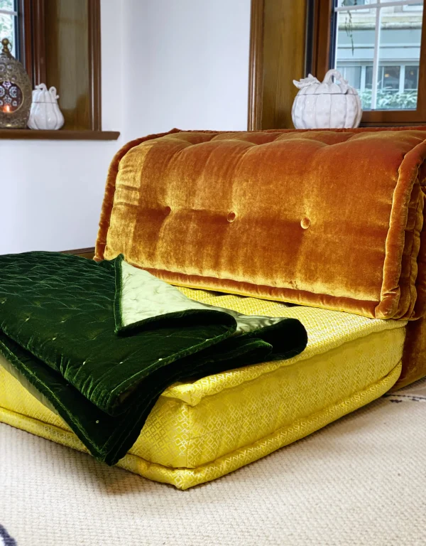 Full view of Mah Jong daybed sofa with velvet upholstery and colorful layered cushions.