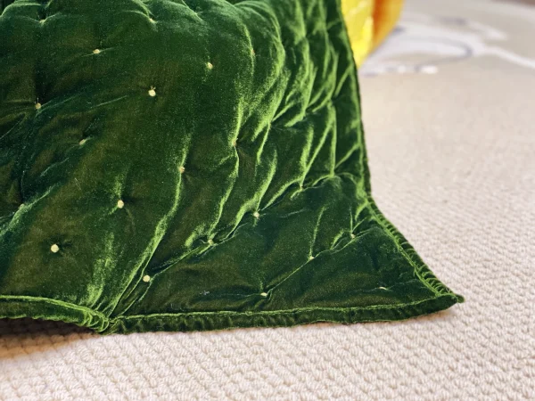 Close-up of green velvet quilted cover with intricate stitching on a French daybed Mah Jong sofa.