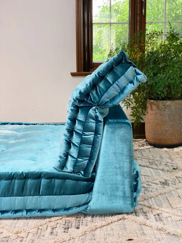 Close-up of the teal Mah Jong sofa’s layered design, showcasing its tufted details and luxurious velvet fabric.