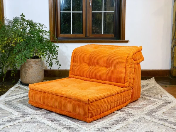 Angled view of the orange French Mah Jong Daybed Sofa highlighting its vibrant color and elegant design.