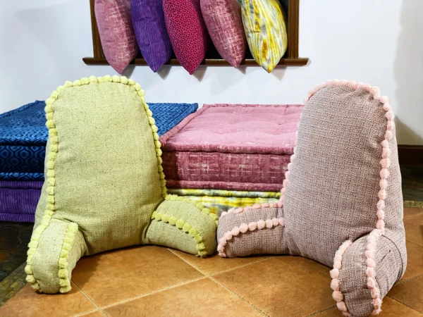 French Mah Jong sofa with vibrant yellow, pink, and purple cushions and a tiled backdrop.