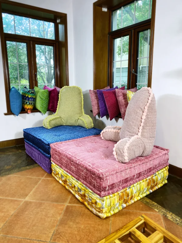 French daybed Mah Jong sofa with stacked colorful modular bases and backrest cushions in a cozy room.