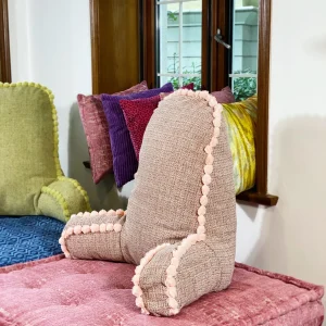 Close-up of a pastel pink textured backrest cushion with pom-pom accents on a Mah Jong daybed.