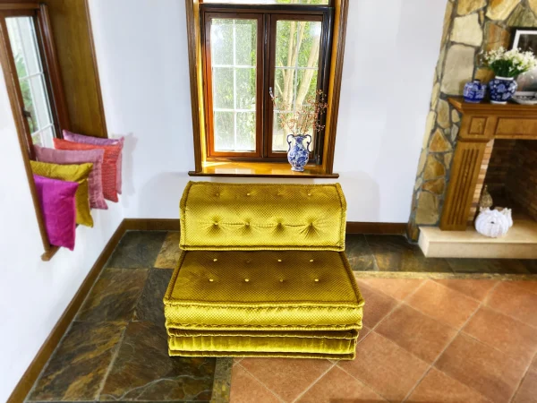 Close-up of the textured golden-yellow upholstery on a French Mah Jong daybed, highlighting its detailed craftsmanship.