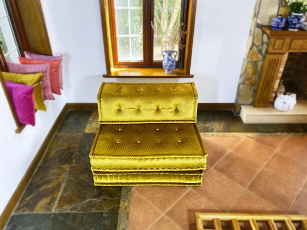 Top-down view of a French Mah Jong daybed in golden yellow, styled with a vase and natural light streaming through the windows.