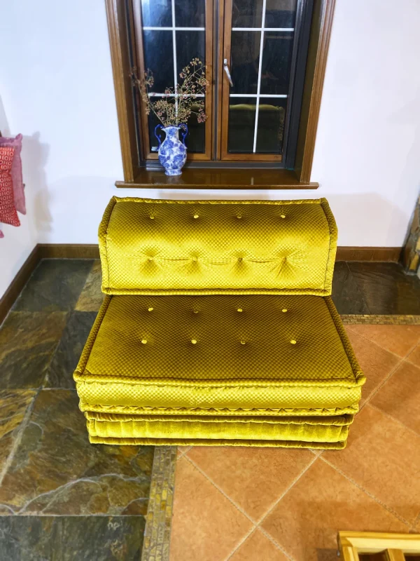 Elegant golden-yellow French Mah Jong daybed styled near a window with a decorative vase and a cozy ambiance.