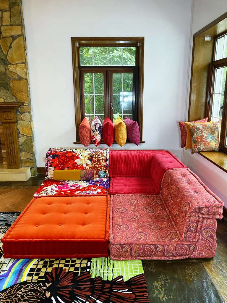 Corner section of a French Mah Jong sofa in red corduroy and paisley prints