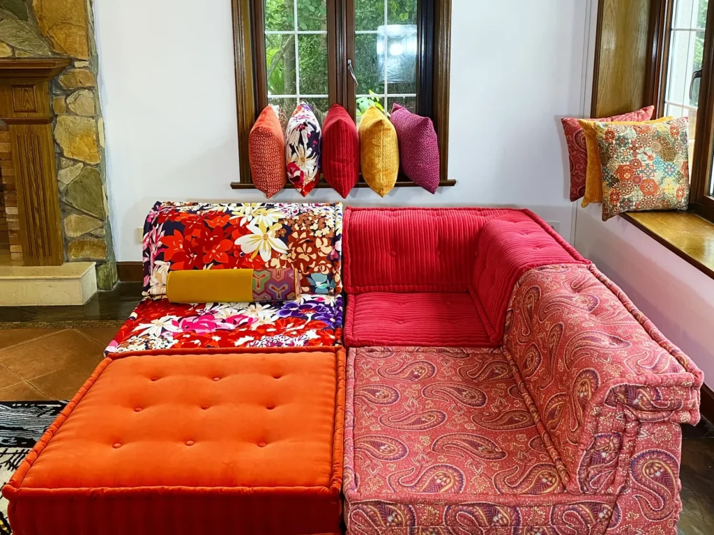 Corner section of a French Mah Jong sofa in red corduroy and paisley prints