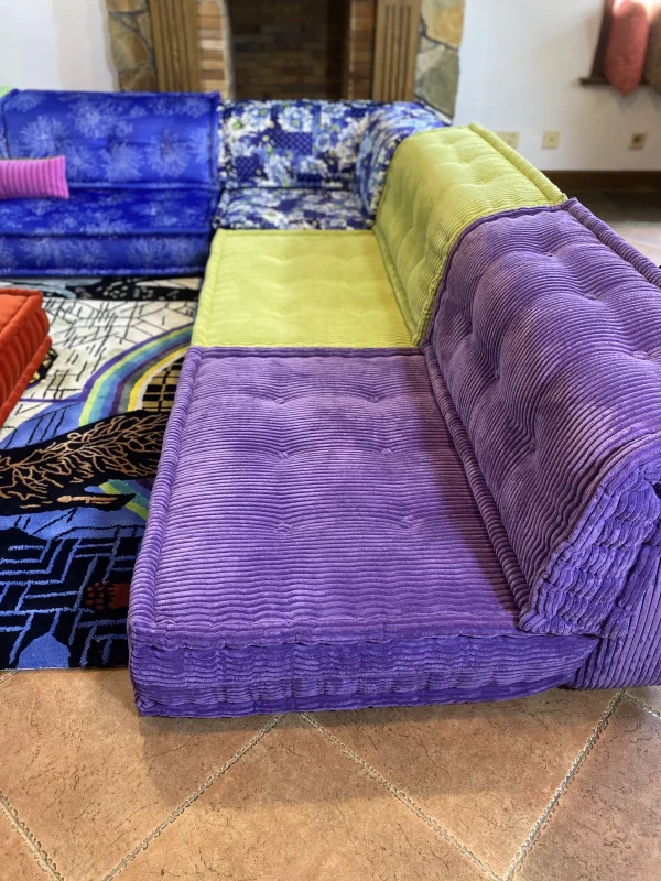 Side view of the Mah Jong sofa with vibrant purple and green corduroy fabric.