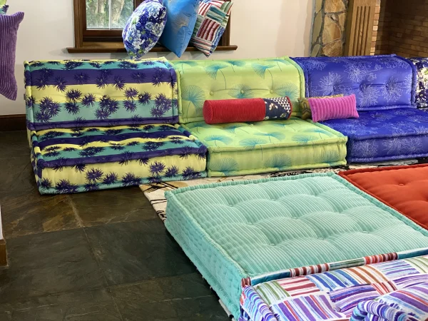 Close-up of Mah Jong sofa showcasing bright green and blue floral patterns with accent pillows.