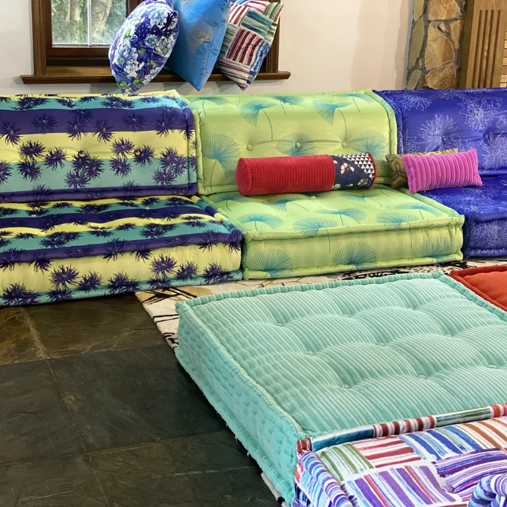 Close-up of Mah Jong sofa showcasing bright green and blue floral patterns with accent pillows.