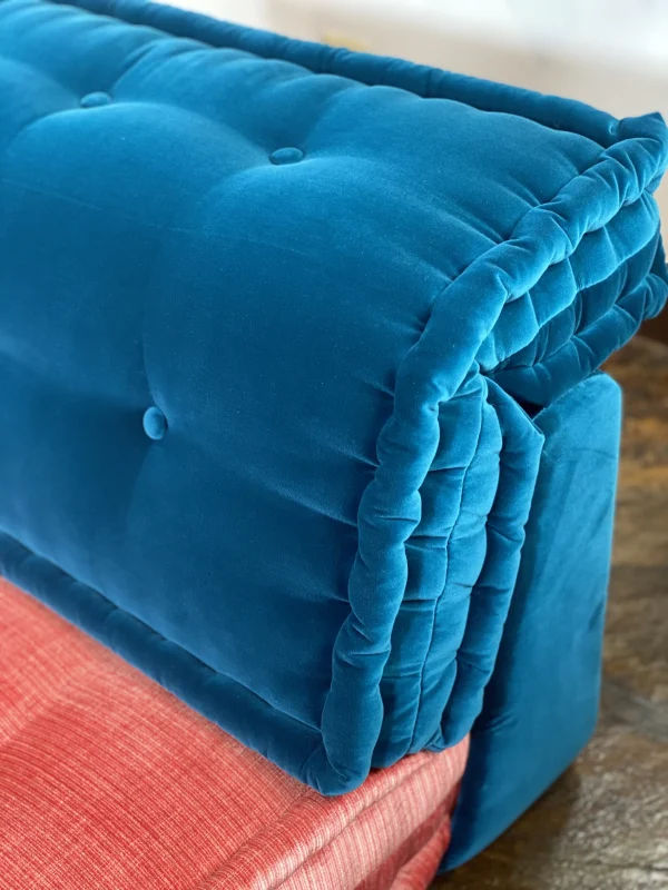 Close-up of the deep blue tufted backrest of a Mah Jong-style sofa, showcasing its soft velvet fabric.